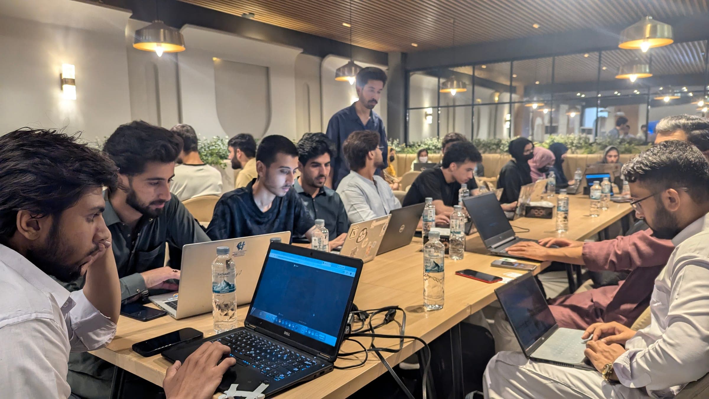 Developers coding on laptops at a long table
